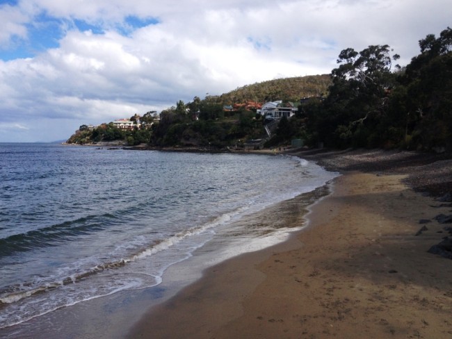 View south from Blinking Billy Point in Sandy Bay towards the volcanic rocks on Charles Darwin Cliff at the end of the beach.