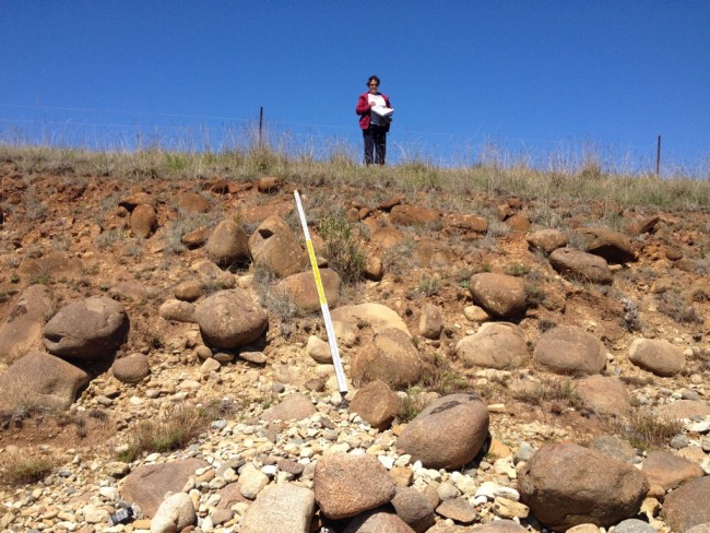 At Kellys Point, looking south to a weakly-cemented orange-brown boulder and cobble bed of rounded dolerite clasts, smaller angular sandstone and siltstone clasts, in a silt/sand matrix.