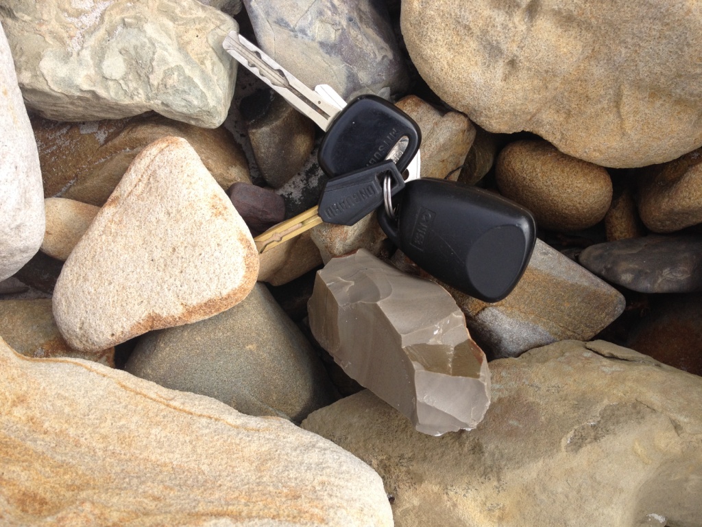 A sharp-edged, tan-coloured scraper appears completely out of place in the intertidal zone on a southern Tasmania beach. A set of keys has been used to indicate scale.