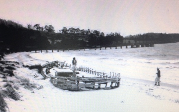 Old black and white photo of the Annie Taylor shipwreck on Rheban Beach showing how she has shifted parallel to the shore, pointing northwest.