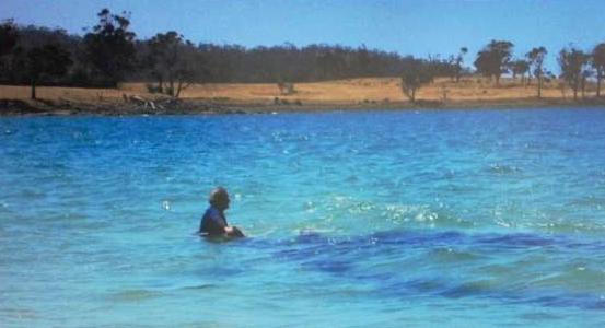 Annie Taylor at low tide on Rheban Beach in clear, blue water.