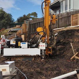 Geotechnical drilling at the head scarp of a landslide undermining a house in southern Tasmania.